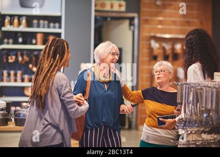 Les femmes heureuses parlent de shopping dans le magasin de biens de maison Banque D'Images