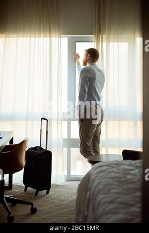 Homme d'affaires dans la chambre d'hôtel avec une fenêtre Banque D'Images