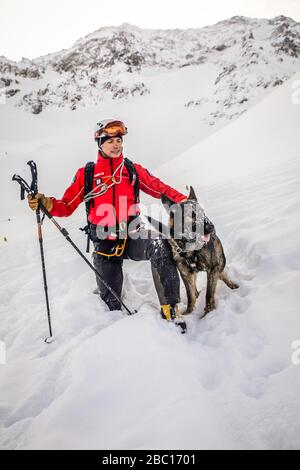 ÉQUIPE D'AVALANCHE DE CHIEN ET DE MANUTENTIONNAIRE, À LA RECHERCHE DE VISITIMS DANS UNE AVALANCHE, POMPIERS NATIONAUX EXECISE DANS LE SAUVETAGE EN AVALANCHE, COL DU LAUTARET, HAUTES ALPES (05) Banque D'Images