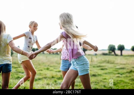 Des filles heureuses dansant ensemble sur un terrain Banque D'Images