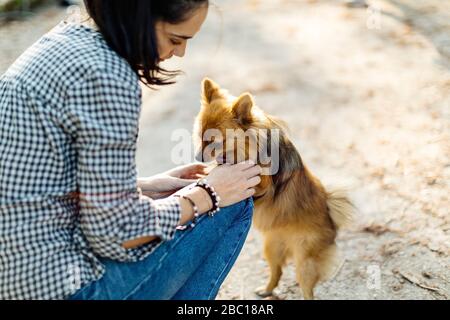 Jeune femme jouant avec le chien à l'extérieur Banque D'Images