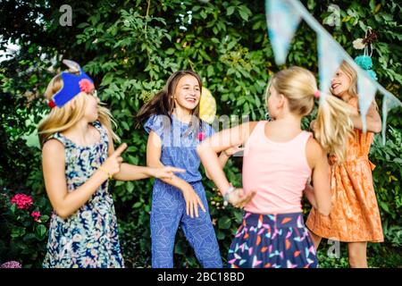 Des filles heureuses dansant lors d'une fête d'anniversaire à l'extérieur Banque D'Images