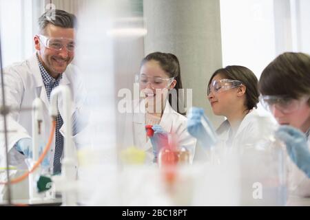 Professeur et étudiants de sexe masculin menant des expériences scientifiques en salle de classe de laboratoire Banque D'Images