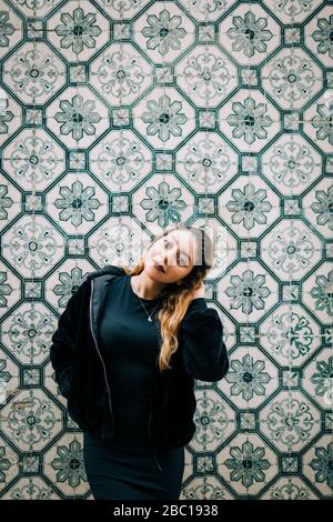 Portrait de la jeune femme vêtue de noir devant le mur d'Azulejo, Lisbonne, Portugal Banque D'Images