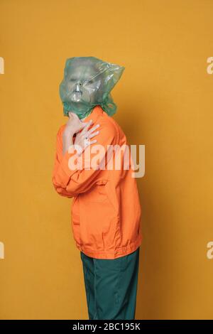 Portrait de la jeune femme portant une veste orange devant un fond jaune Banque D'Images