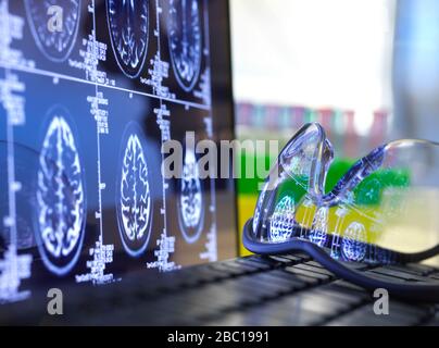 L'acquisition cérébrale se traduit par des lunettes de protection sur le clavier de l'ordinateur portable Banque D'Images