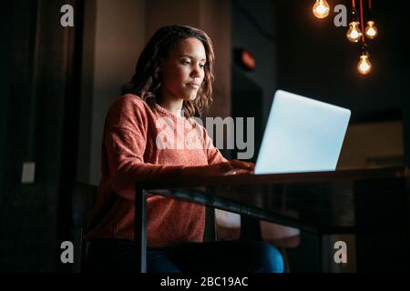 Young woman using laptop in a cafe Banque D'Images