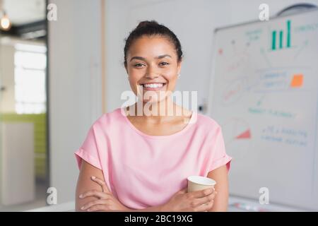 Portrait confiant, femme d'affaires enthousiaste au tableau blanc dans la salle de conférence Banque D'Images