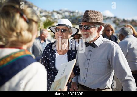 Couple touristique senior actif parlant avec guide touristique Banque D'Images