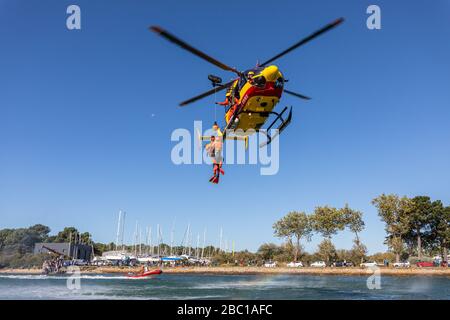 WINCHING D'UN SAUVEUR ET D'UNE VICTIME, L'EXERCICE DE SAUVETAGE EN MER DANS LE GOLFE DU MORBIHAN AVEC LES POMPIERS ET L'HÉLICOPTÈRE DES SERVICES CIVILS D'URGENCE, VANNES, FRANCE Banque D'Images