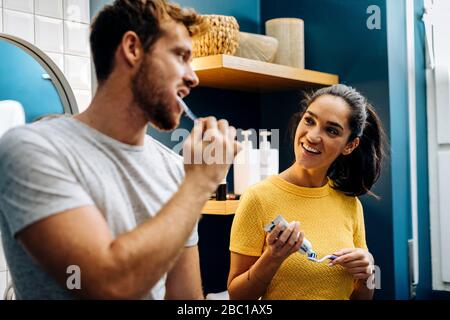 Les jeunes couples se brossent les dents dans la salle de bains à la maison Banque D'Images