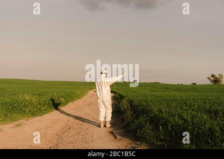 Homme portant un costume de protection et un masque dans la campagne Banque D'Images