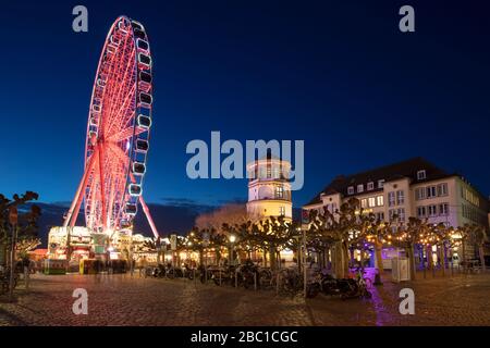 Allemagne, Rhénanie-du-Nord-Westphalie, Düsseldorf, Burgplatz la nuit avec roue éclairée Ferris en arrière-plan Banque D'Images