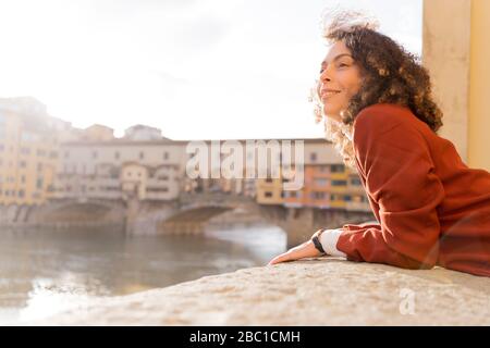 Femme au fleuve Arno près du Ponte Vecchio, Florence, Italie Banque D'Images