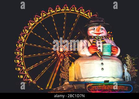 Allemagne, Hambourg, vue à angle bas de la sculpture de bonhomme de neige contre la roue de ferris en neige la nuit Banque D'Images