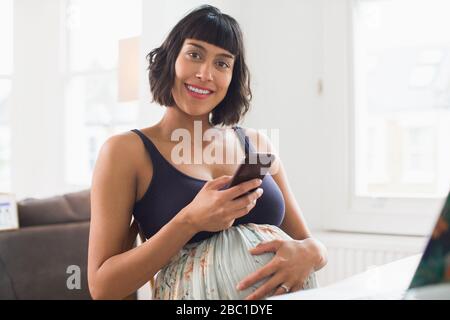 Portrait bonne femme enceinte utilisant un smartphone Banque D'Images