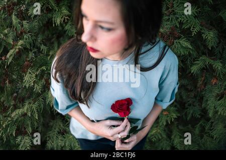 Vue sur la récolte d'une femme avec rose rouge Banque D'Images