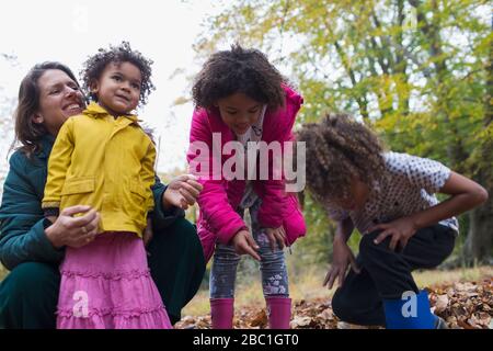 Bonne mère et enfants jouant en automne quitte Banque D'Images