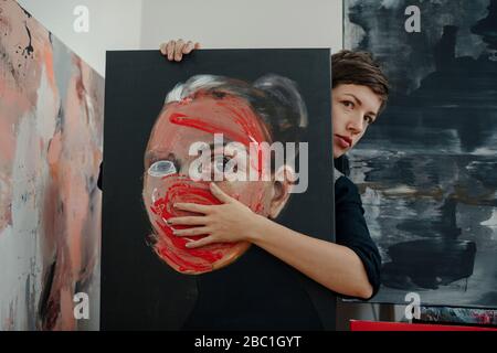 Portrait d'une femme peintre avec peinture dans son studio Banque D'Images