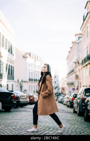 Portrait de la jeune femme à la mode traversant la rue, Lisbonne, Portugal Banque D'Images