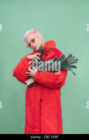 Portrait de la jeune femme avec des cheveux roses courts portant un manteau rouge Banque D'Images