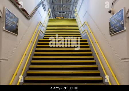 Alors que la deuxième semaine du verrouillage de Coronavirus continue le nombre de morts au Royaume-Uni augmente de 569 à 2 921, avec un chiffre de 1 m signalé des cas de passage de Covid-19 dans le monde entier, les marches jaunes vides menant à une plate-forme de la gare de Herne Hill dans le sud de Londres, le 2 avril 2020, À Londres, en Angleterre. Banque D'Images