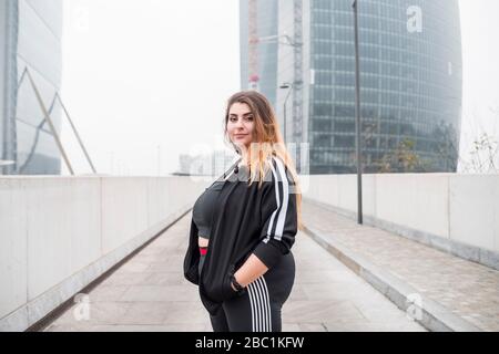 Plus petite jeune femme sportive qui pose dans la ville Banque D'Images