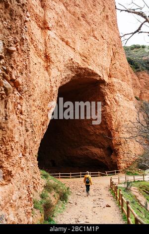 Randonneur à l'entrée d'un tunnel, Mina de Oro Romana, ancienne mine d'or, Las Medulas, Castille et Leon, Espagne Banque D'Images