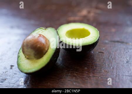 Un tranches en demi-avocat vert frais avec la fosse à l'intérieur prêt à être utilisé dans un snack ou un repas. Banque D'Images