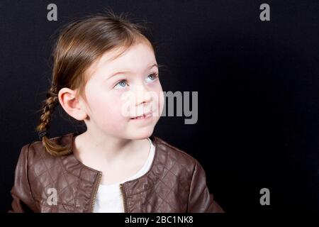 Jolie petite fille avec coupe de cheveux bobinée donnant à l'extérieur de l'appareil photo Banque D'Images