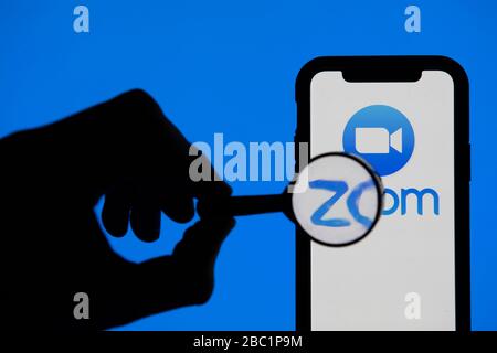 LONDRES, Royaume-Uni - 2 avril 2020: Loupe regardant l'application de conférence vidéo Zoom sur un smartphone Banque D'Images