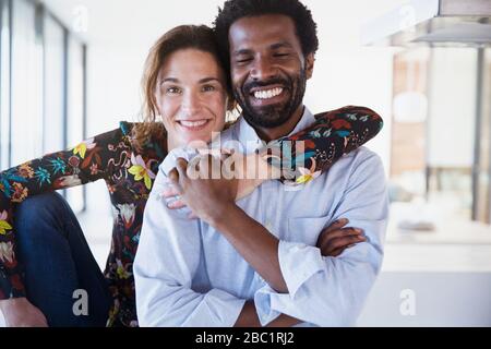 Portrait souriant, confiant couple multi-ethnique embrassant Banque D'Images