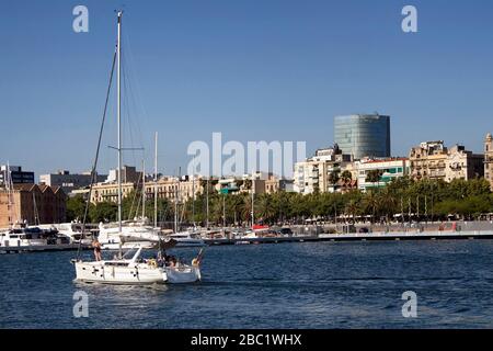 Vue sur un voilier arrivant dans la marina de Barcelone appelée 'Port de plaisance Vell. C'est une journée d'été ensoleillée. Banque D'Images