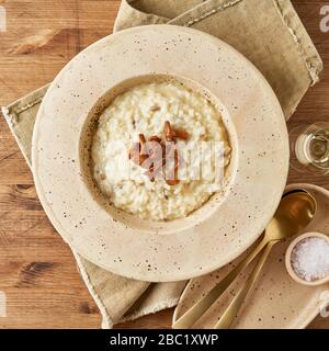 Risoto avec chanterelle champignons dans grande plaque. Plat italien traditionnel. Vieille table en bois Banque D'Images