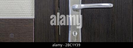 Éléments de fermeture de poignée de porte. Porte en bois fermée dans un style moderne à l'intérieur. Poignée de porte, accessoires pour le design intérieur. Intérieur d'une maison Banque D'Images