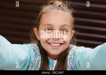 Cute little girl prenant une avec un téléphone mobile selfies en extérieur. Banque D'Images