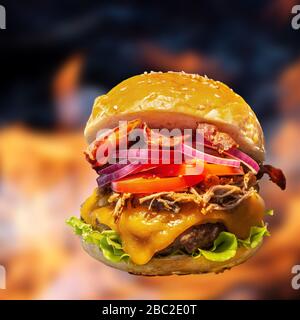 Gros plan de hamburgers faits maison avec flammes de feu. Banque D'Images