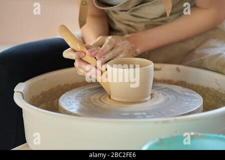 Femme faisant de la céramique poterie sur la roue, les mains se rapprosigent, se concentrer sur les potiers, les paumes avec la poterie Banque D'Images