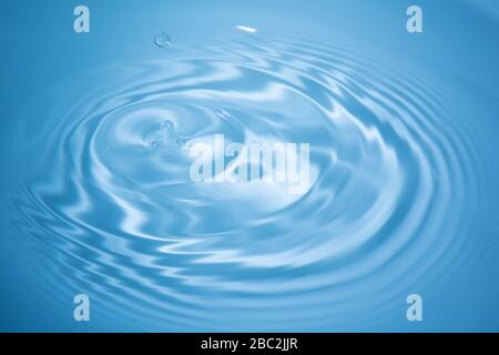 Goutte d'eau tombe dans l'eau bleue Banque D'Images
