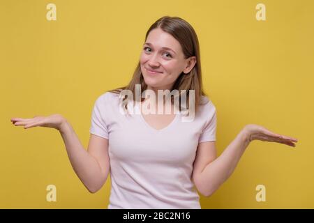 Jeune femme montrant deux espaces vides de copie, prendre une décision entre les produits ou services alternatifs, les avantages de pesage et les inconvénients. Studio tourné Banque D'Images