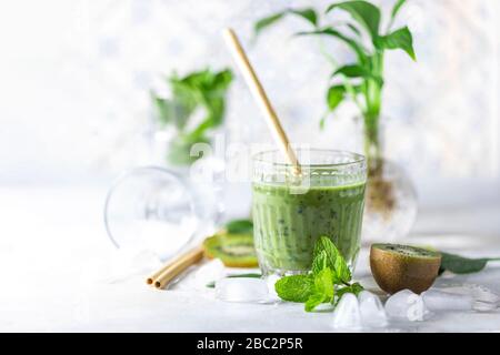 Smoothie vert DETOX - kiwi, épinards et matcha sur fond gris clair ardoise, pierre ou béton. Mise au point sélective, espace de copie. Vue de dessus. Banque D'Images