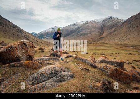 Coureur de montagne. L'athlète court dans les montagnes parmi les rochers. L'homme s'entraîner en plein air. Course sur piste Banque D'Images