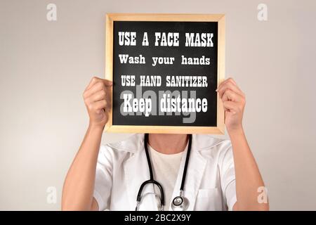 Médecin donnant des recommandations pour éviter de devenir infecté par le covid-19 utilisez un masque facial, lavez-vous les mains, utilisez un désinfectant pour les mains et gardez la distance Banque D'Images