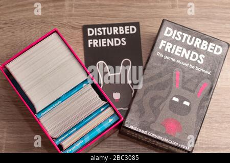 Jeu de fête populaire « Disturbed Friends ». Ouvrez la boîte avec des cartes empilées en groupes sur la gauche, concentrez-vous sur le logo et le nom du jeu Banque D'Images