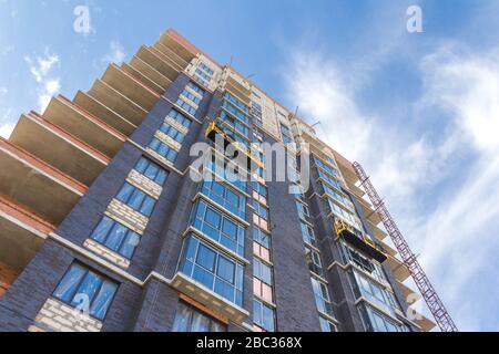 Berceau de construction sur la façade arrière-plan du bâtiment en construction. La façade travaille avec le berceau de construction Banque D'Images