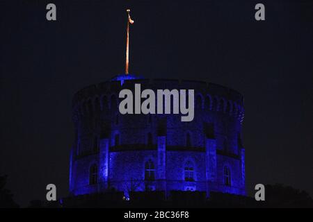 Le château de Windsor est devenu bleu pour saluer les héros locaux dans le cadre de l'initiative nationale de jeudi de Clap for Carers NHS visant à applaudir les travailleurs du NHS qui luttent contre la pandémie de coronavirus lorsque des sites touristiques du Royaume-Uni seront éclairés en bleu. Banque D'Images