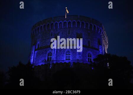 Le château de Windsor est devenu bleu pour saluer les héros locaux dans le cadre de l'initiative nationale de jeudi de Clap for Carers NHS visant à applaudir les travailleurs du NHS qui luttent contre la pandémie de coronavirus lorsque des sites touristiques du Royaume-Uni seront éclairés en bleu. Banque D'Images