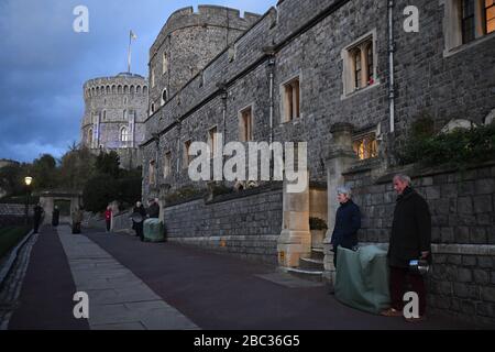 Les résidents du château de Windsor, alors qu'il est devenu bleu pour saluer les héros locaux au cours de l'initiative nationale de Clap for Carers NHS de jeudi pour applaudir les travailleurs du NHS qui combattent la pandémie de coronavirus lorsque les sites touristiques du Royaume-Uni seront éclairés en bleu. Banque D'Images