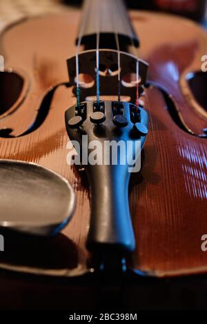 Gros plan d'un violon montrant la texture du corps et des cordes en bois. L'éclairage doux et la faible profondeur de champ sont également utilisés pour améliorer cette image. Banque D'Images