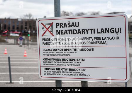 Un panneau affichant des règles en lituanien, anglais, russe et polonais, dans un centre d'essai temporaire, à passage en voiture de coronavirus / COVID-19 à Vilnius Banque D'Images